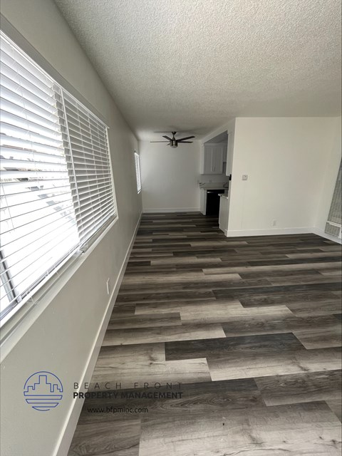 a living room with a wood floor and a ceiling fan